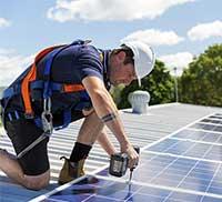 Worker on rooftop with solar panels